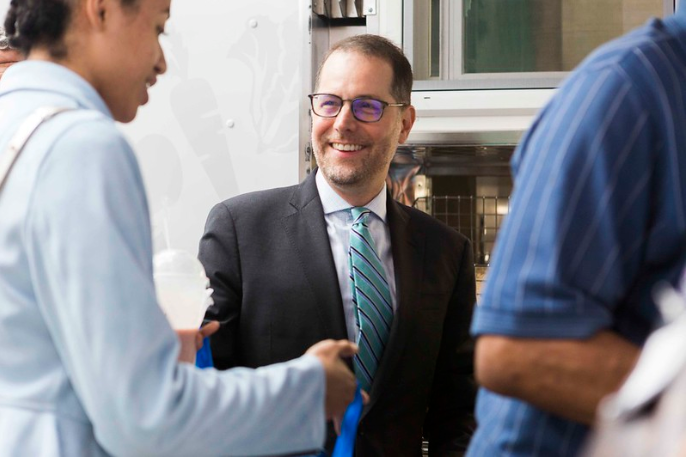 Mark Levine smiling while talking to community member