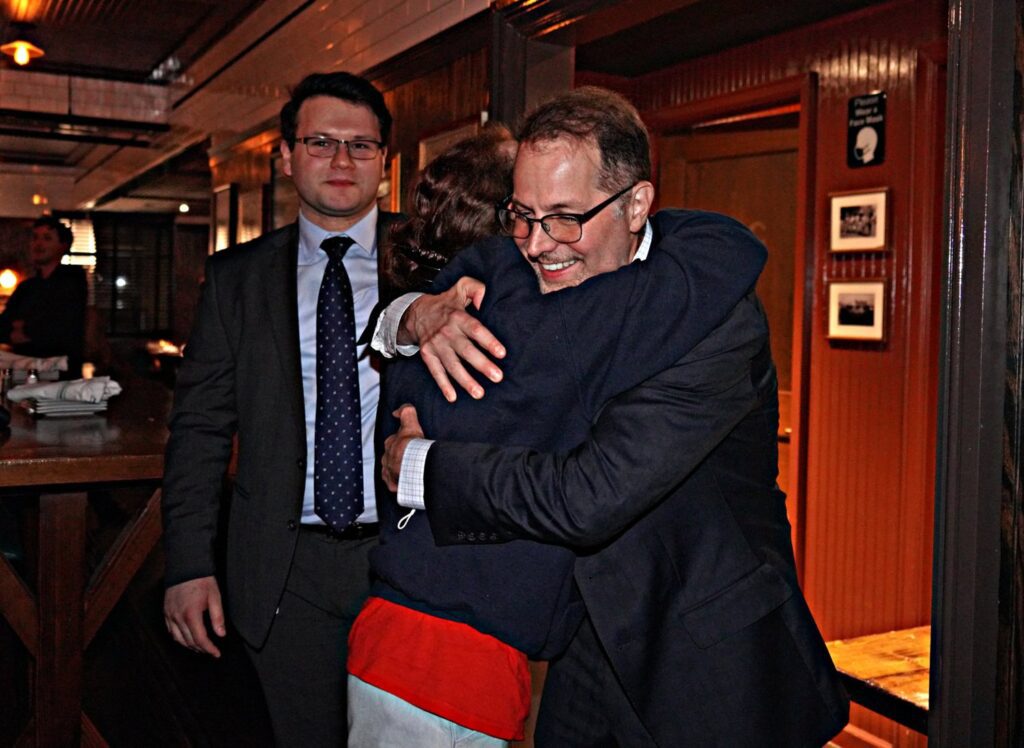Mark Levine hugs community member